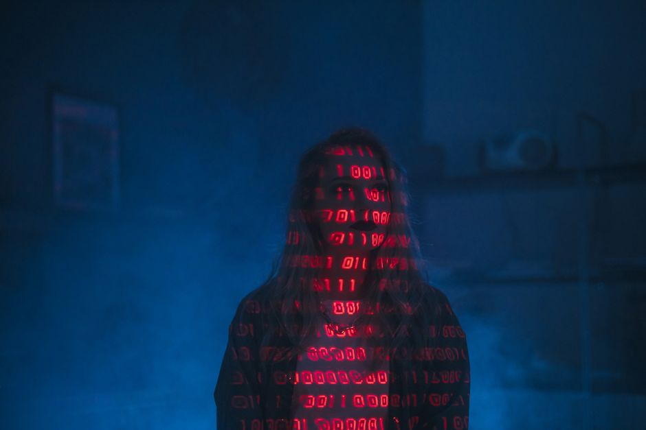 A close-up view of a computer screen displaying a code editor filled with lines of HTML and CSS code in various colors, including red, green, blue, and purple, on a dark background. The code appears t